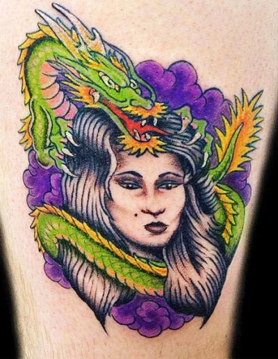 Green dragon coiled around a woman's thigh tattoo