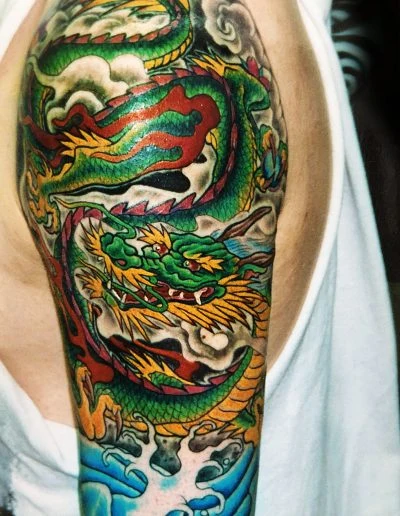Green and gold dragon sleeve wrapping the forearm