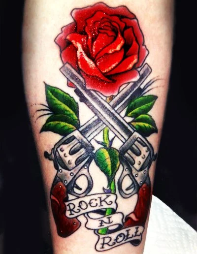Rose over crossed guns with rock and roll banner tattoo